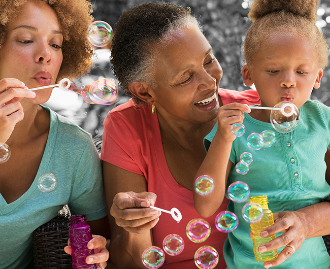 three generations of women blowing bubbles