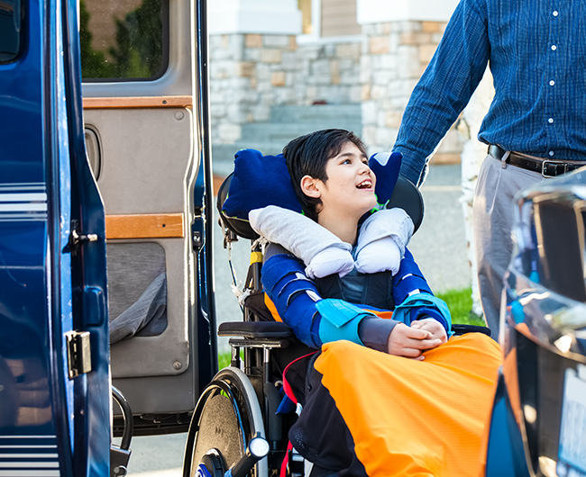 boy in wheelchair going into van